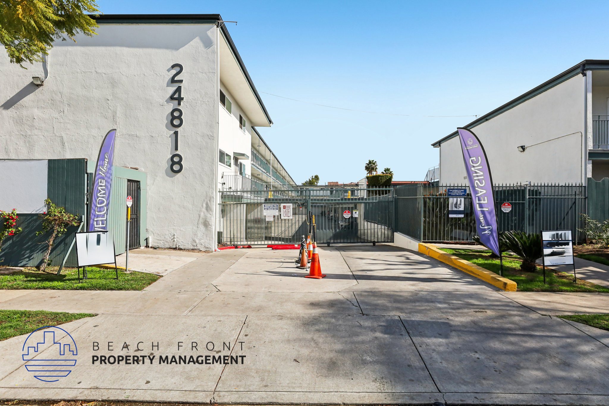 The image shows a building with the number 24818 on it, surrounded by a fence and a couple of flags.